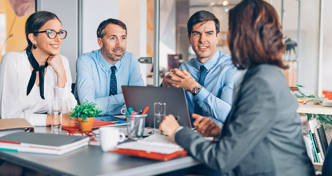 Seller meets a target account's buying group at a conference table, a core moment in account-based marketing