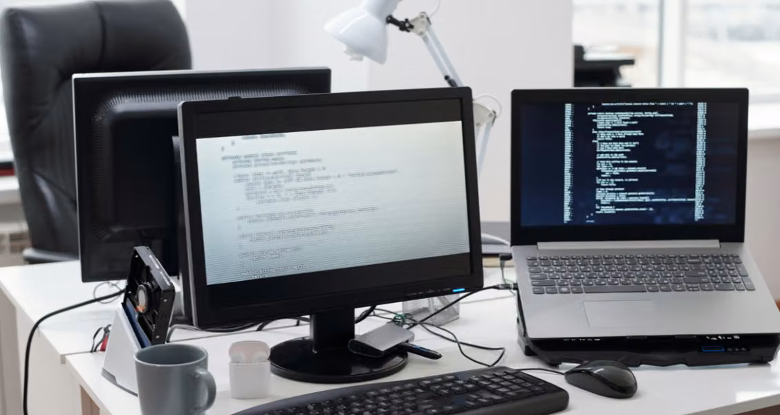 Desk with dual monitors comparing microsite builder platforms side by side