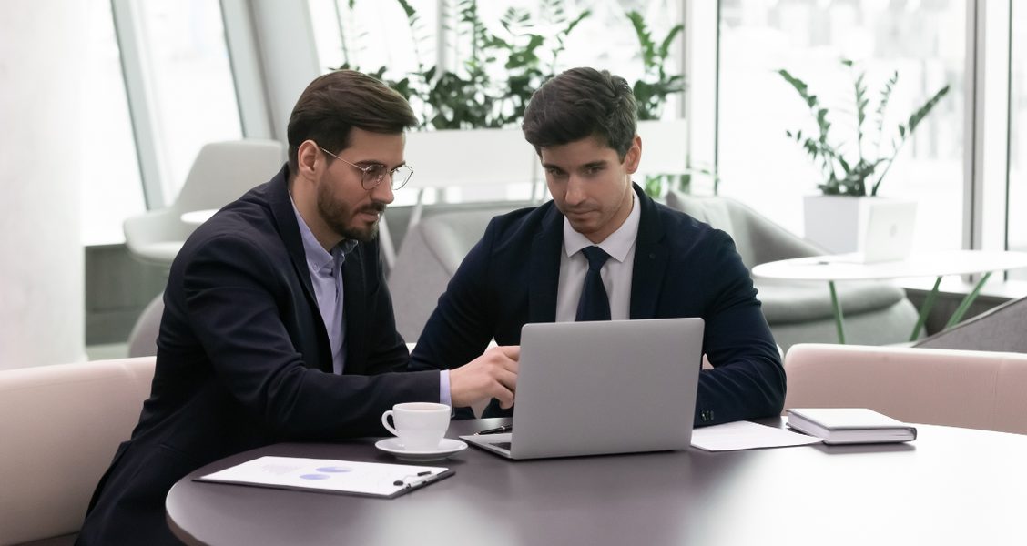 Sales rep and buyer reviewing deal content together on a laptop