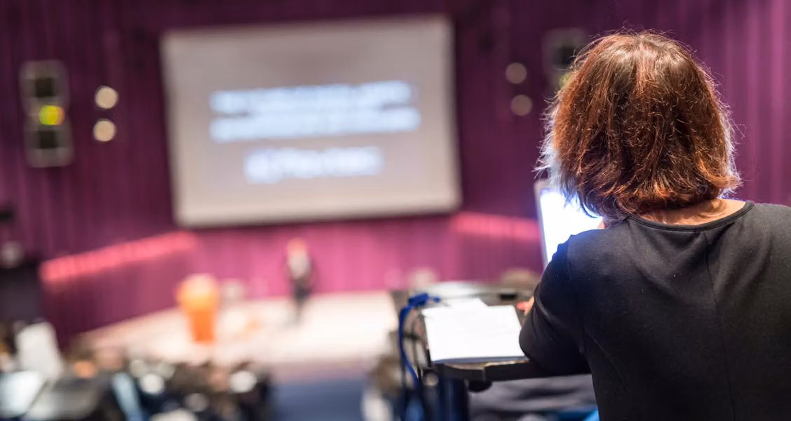 Speaker presenting to a live audience at a conference event