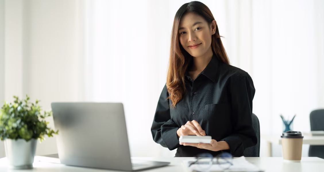 Sales enablement leader reviewing vendor comparison documents and charts at a laptop in a modern office