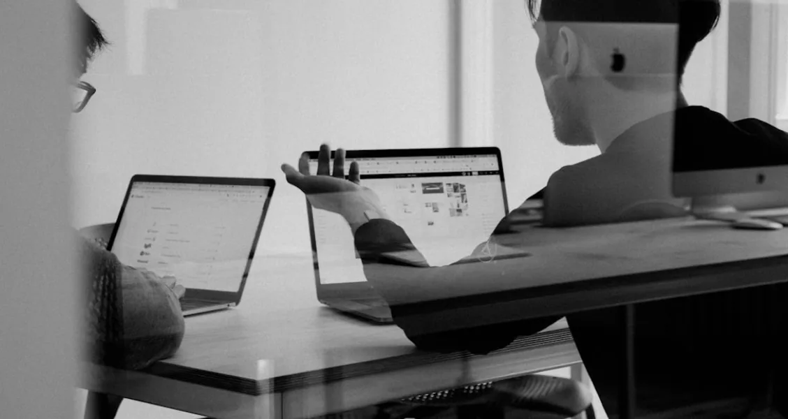 Sales professional composing a follow-up email after sending a proposal on a laptop
