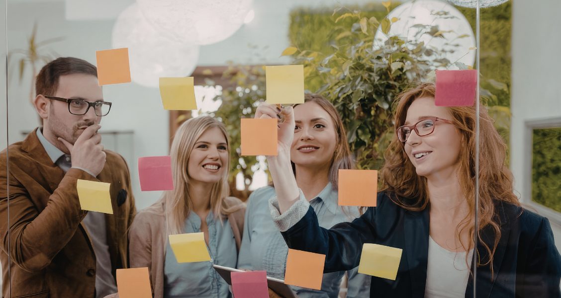 Comms team maps an internal communications plan with sticky notes on a glass wall