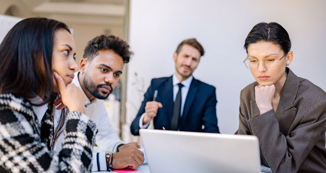 Enterprise hiring leaders comparing recruitment marketing platforms in a meeting room