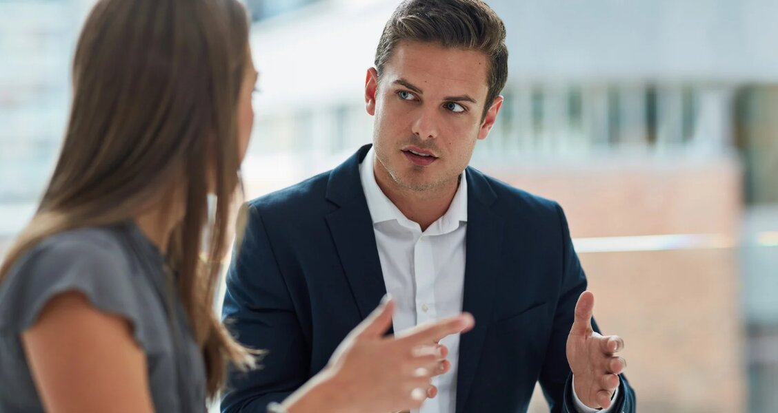 Two sales professionals in a calm, collaborative conversation raising and addressing a concern