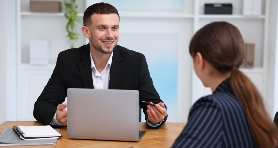 Sales professional reviewing a sales proposal template on a laptop at a desk