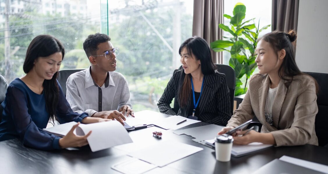 Two sales reps practicing a role-play scenario at a desk