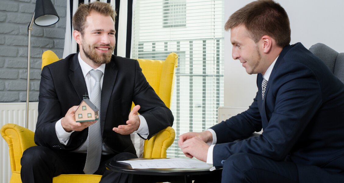 Two sales professionals in a calm, balanced negotiation conversation across a table