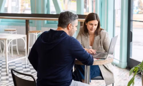 Two persons watching a laptop