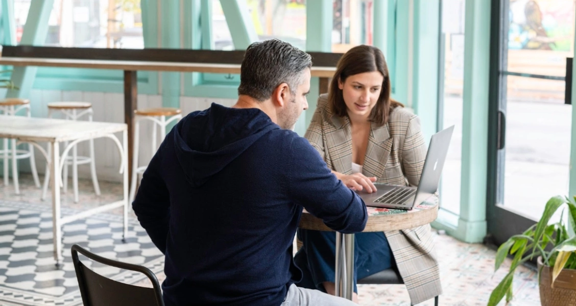 Two persons watching a laptop