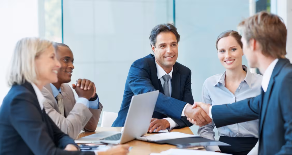 Sales rep and prospect reviewing a cost calculation together on a laptop