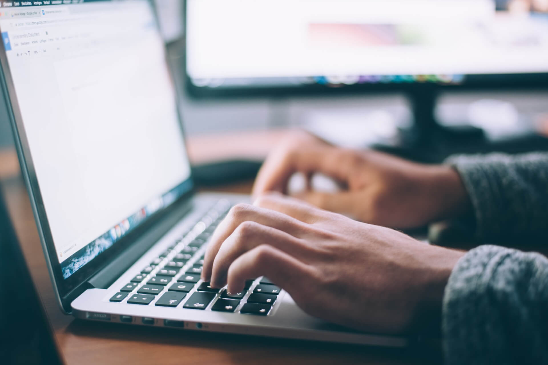 Pair of hands typing on a laptop.