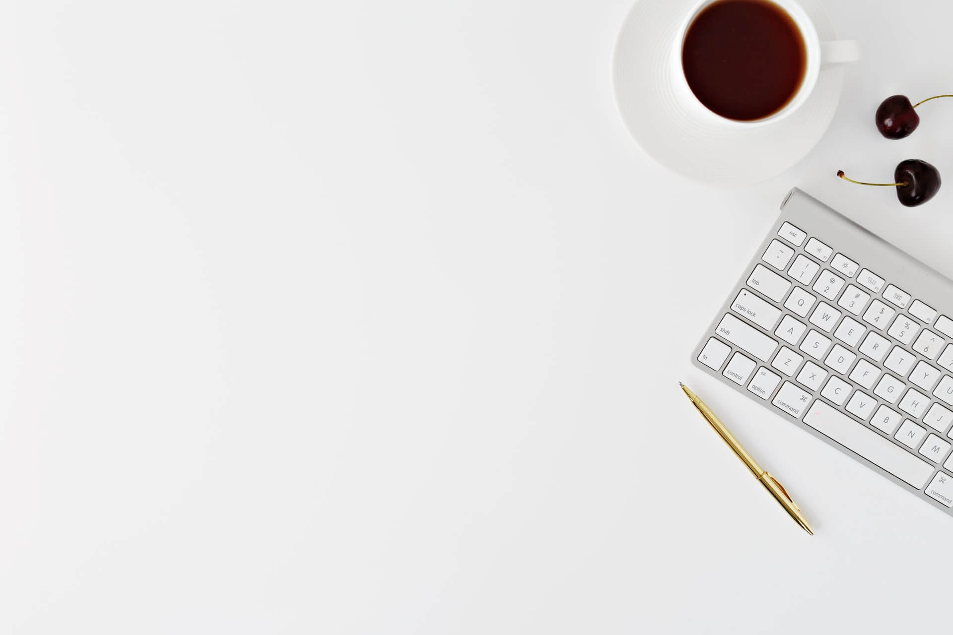 Keyboard, cup of coffee and a pen.