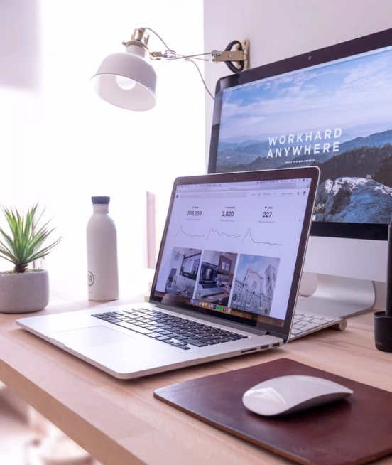 A desk with a laptop, a monitor, a keyboard and a computer mouse.