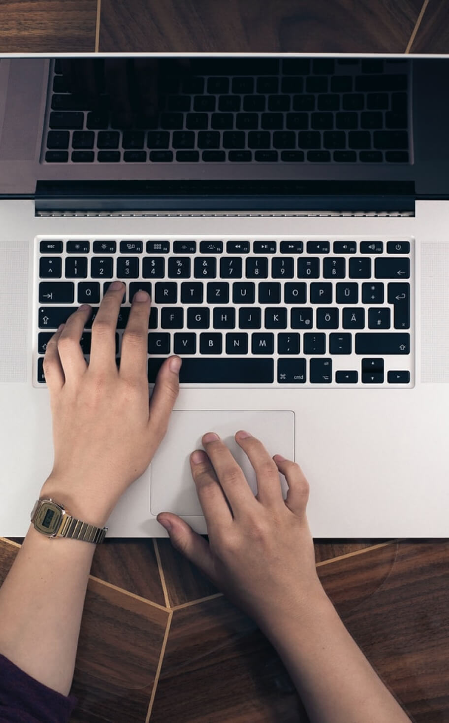 A pair of hands typing on a laptop.