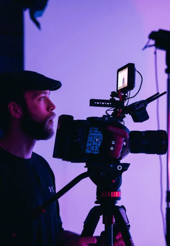 A man operating a digital video camera.