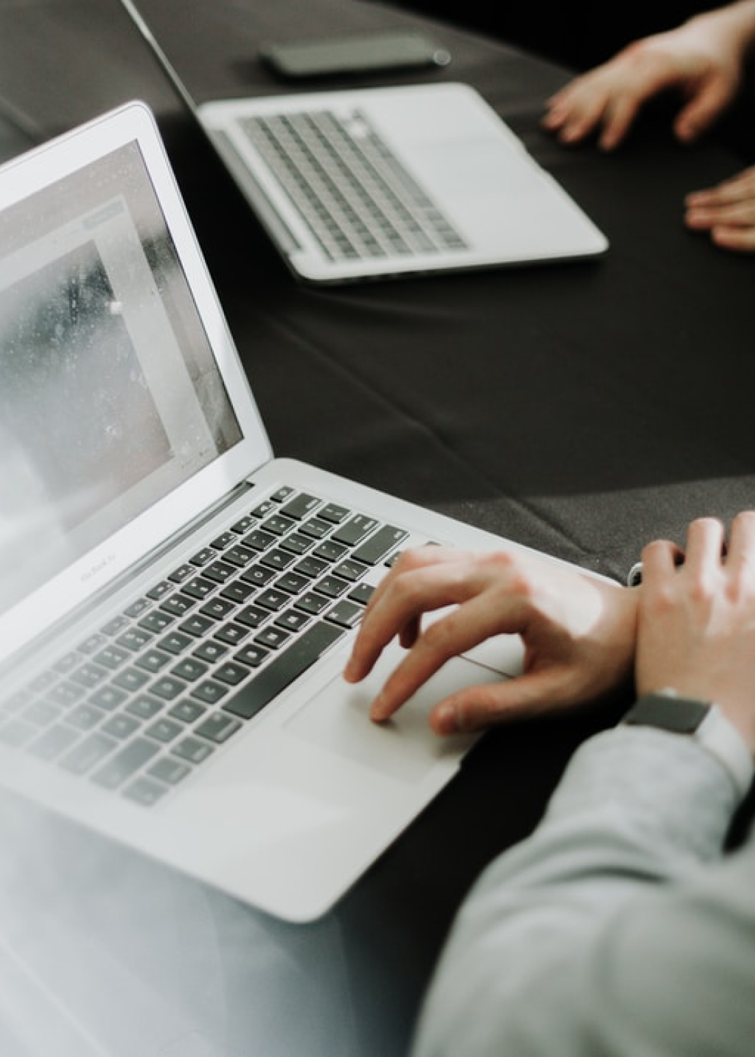 Two laptops being used on a desk